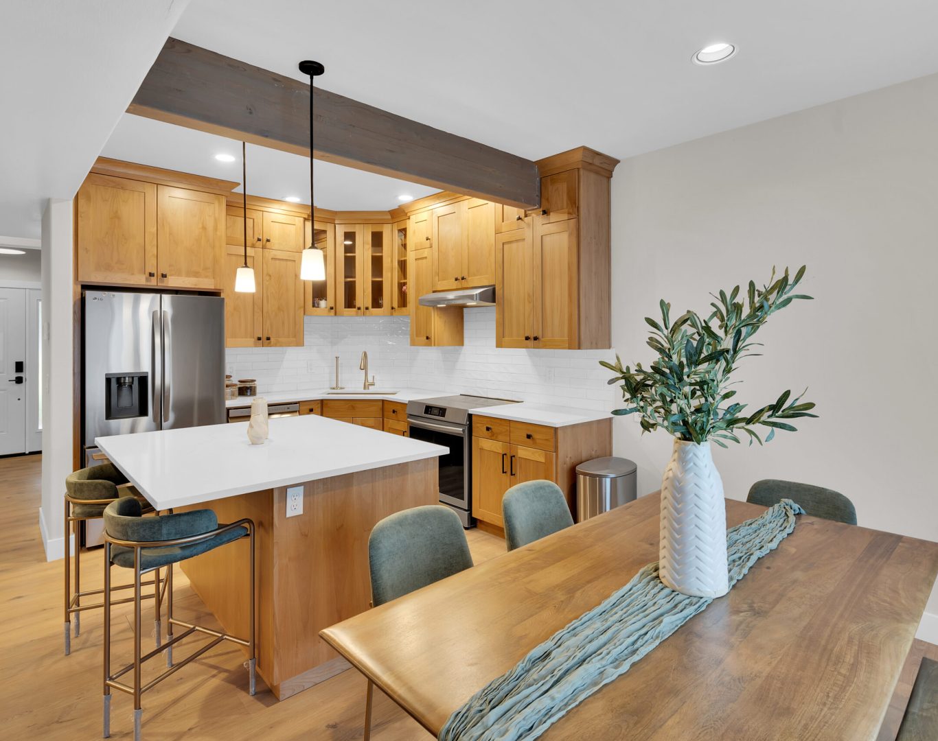 Spacious modern kitchen featuring white cabinets, marble countertops, and an island with stainless steel fixtures.