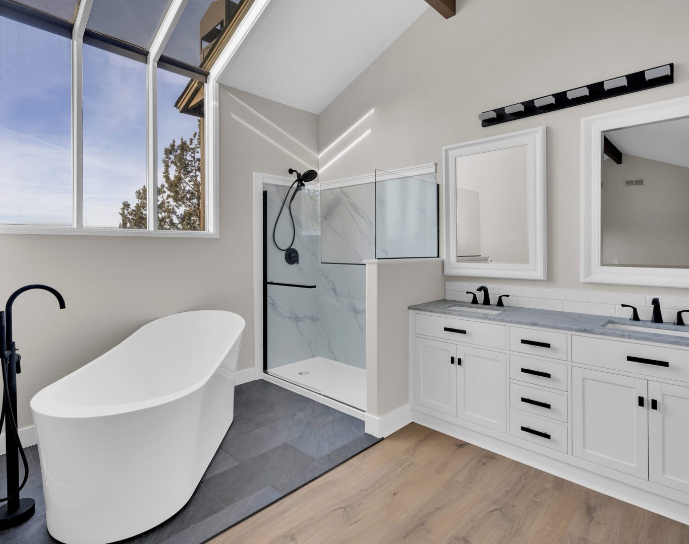 Elegant white bathroom with glass shower and stylish patterned floor.